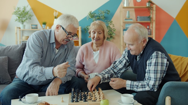 old people playing a game sat down in a care home