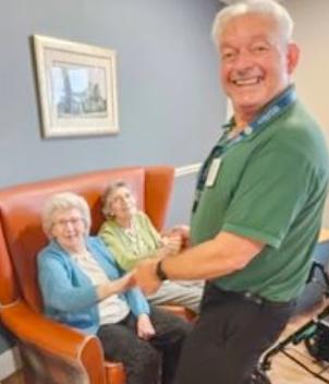 residents with staff smiling at entertainment